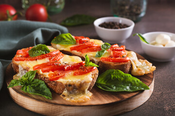 Baked sandwiches with caprese salad from tomatoes and cheese on the board