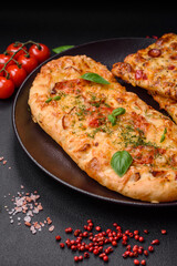 Delicious oven fresh flatbread pizza with cheese, tomatoes, sausage, salt and spices