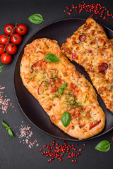 Delicious oven fresh flatbread pizza with cheese, tomatoes, sausage, salt and spices