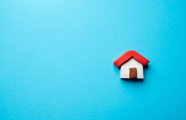 Miniature house on a blue background. Buying and selling housing. Construction industry. Design and architectural services. Property insurance. Real estate market review.