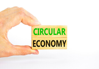 Circular economy symbol. Concept words Circular economy on beautiful wooden block. Beautiful white table white background. Businessman hand. Business circular economy concept. Copy space.