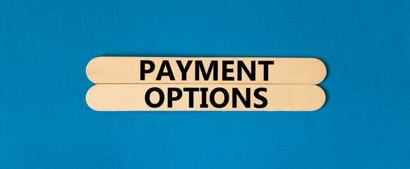 Payment options symbol. Concept words Payment options on beautiful wooden stick. Beautiful blue table blue background. Business payment options concept. Copy space.