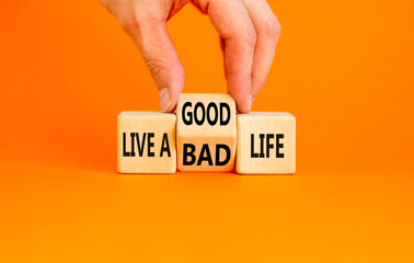 Live good life symbol. Concept word Live a good or bad life on wooden block on a beautiful orange...