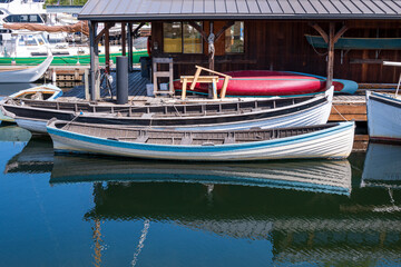 Fototapeta na wymiar Historic wooden row boats moored at a dock on a summer day. Shot in Seatle Washington on the waterfornt.