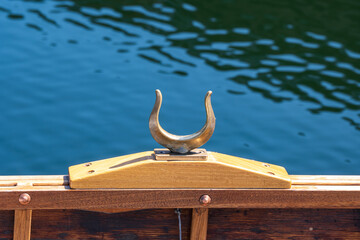 traditional metal brass oar lock close up on a classic wooden row boat