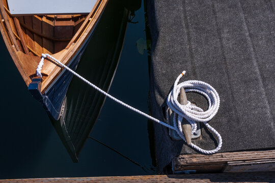boat mooring line (white) tied to a dock cleat and coiled