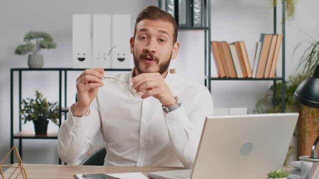 Middle eastern business man taking off, throwing out glasses into bin after vision laser treatment therapy, looking smiling at camera, cure recovery, improvement of vision. Freelancer guy at office