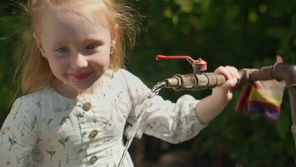Little child girl funny catch water. Kid trying to lick water like dog. Girl drinking fresh water. Funny child. 4K, UHD