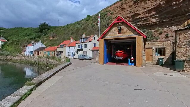 Staithes, North Yorkshire, UK &ndash; June 22 2023. Panning shot of the River Esk and quay in the seaside town of Staithes on the North Yorkshire coast