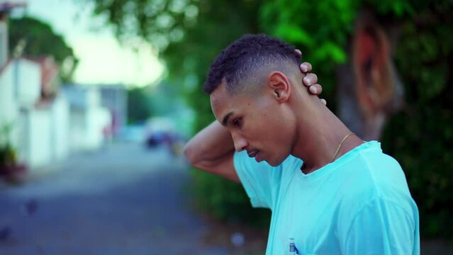One thoughtful Black Brazilian man walking in street brooding decision. Contemplative African American descent person walks forward pondering dilemma