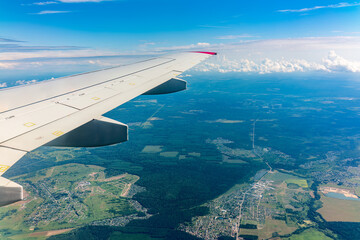 Obraz premium View from the airplane window at a beautiful cloudy sky and the airplane wing