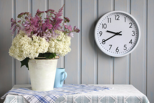 still life with a bouquet and a wall clock in the cottage interior. Hosta, hydrangea, astilba and yarrow.