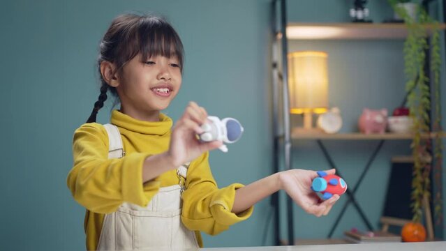 Little girl playing with toy space rocket in the living room.