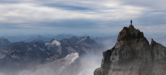 Epic Adventure Composite of Man Hiker on top of a rocky mountain.