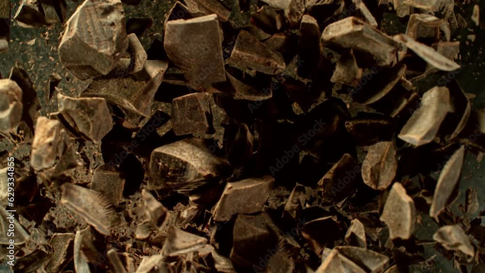 Poster super slow motion of rotating group of raw chocolate pieces. super fast camera motion. filmed on hig