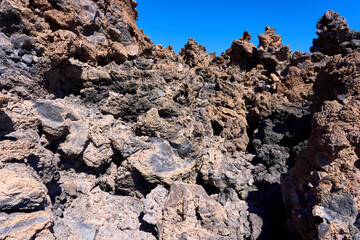 The texture of the volcanic surface. Pumice stone and frozen lava against a blue sky