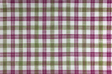 Green and pink checkered texture fabric, tartan pattern. Shirt fabric, tablecloth textile, linen plaid cloth, classic scottish check pattern. Backdrop, wallpaper, background.