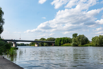 Rzeka Odra, w tle most lekko pochmurna pogoda, błękit nieba zieleń przy brzegu, pora letnia,...