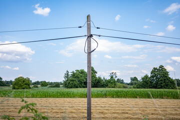 krajobraz linii elektrycznej pośrodku zielonych pól w zachodniej Polsce, jasne zielono niebieskie kolory lekko pochmurna pogoda © FIOMI
