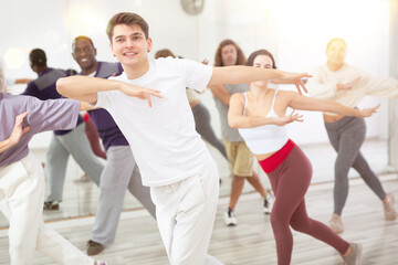 Happy caucasian man learning new modern dance in group dance lesson