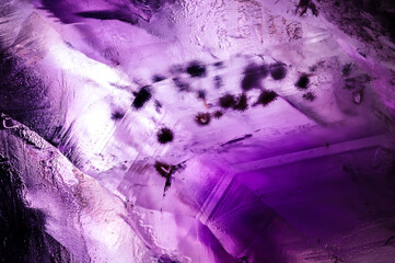 amethyt quartz with hematite spike macro detail texture background. close-up raw rough unpolished semi-precious gemstone druse