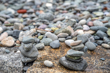 Fototapeta na wymiar Smooth stacked gray pebbles on a tranquil Massachusets shoreline