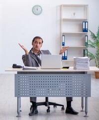 Young male employee unhappy with excessive work in the office