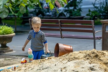 little child playing in sandbox