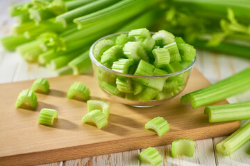 Sliced fresh celery or celery stalk on cutting wooden board.
