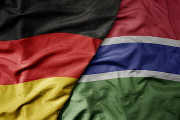 big waving realistic national colorful flag of germany and national flag of gambia