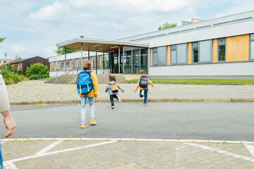 Back to school. A caring father escorts the children to school for the start of classes. Parental...