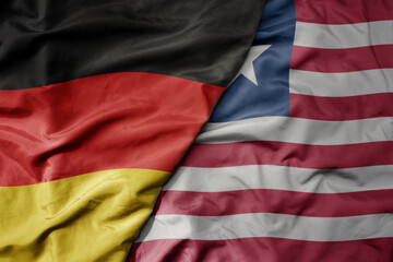 big waving realistic national colorful flag of germany and national flag of liberia .
