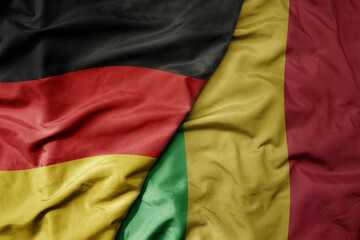 big waving realistic national colorful flag of germany and national flag of mali .