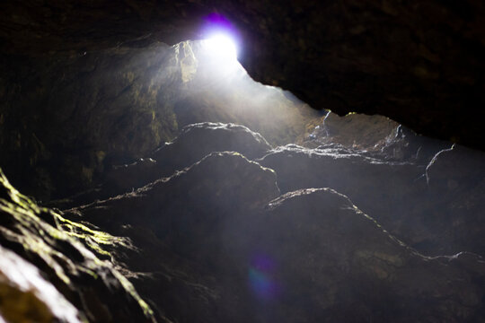 View outside from the depths of the cave, South Urals, Bashkiria. A haze of blackness. July, coolness from the dungeon