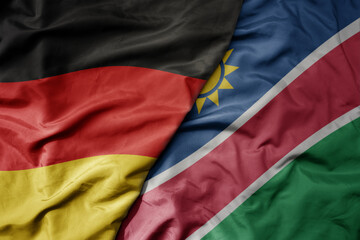 big waving realistic national colorful flag of germany and national flag of namibia .