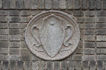 a molded concrete medallion in the art noveau style in neutral beige tones inset on a wall of beige...
