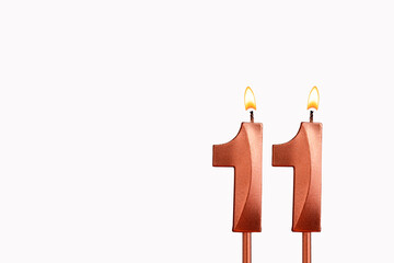 Burning candle number 11 for birthday on white background