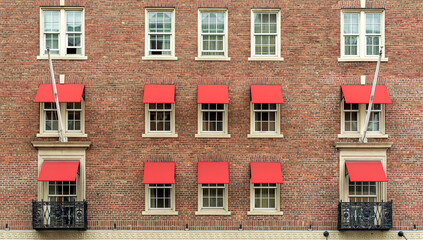 Old brick residential building facade with red window awnings, Boston, Massachusetts, USA