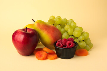 Delicious ripe fruits, raspberries and dried apricots on beige background. Fructose concept
