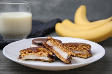 Tasty sweet choco pies on grey wooden table, closeup