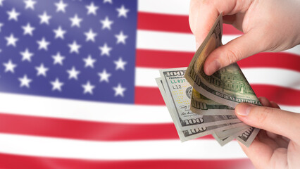 American currency. Dollars in hands. US money. Man counts money. US flag. Financial relations in...