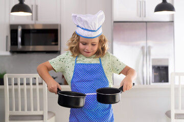 Children cooking in the kitchen. Funny kid chef cook cookery at kitchen. Chef kid boy making...