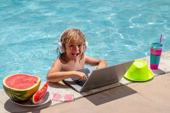 Summer business. Child remote working on laptop in pool. Little business man working online on laptop in summer swimming pool water. Little businessman working on tropical beach.