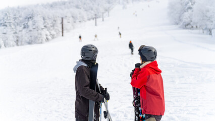 Asian man and woman practice freeriding snowboard and ski on snowy mountain at ski resort. People enjoy outdoor active lifestyle travel nature and winter extreme sport training on holiday vacation. - obrazy, fototapety, plakaty