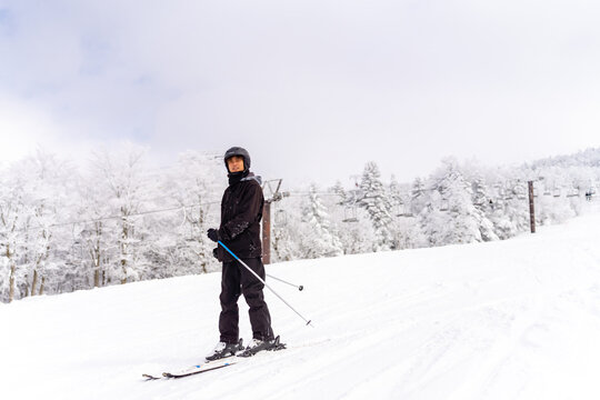 Young Asian man athlete practice downhill sliding skiing on snow mountain at ski resort. Handsome guy enjoy outdoor active lifestyle travel nature and winter extreme sport training on holiday vacation