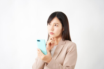 スマートフォンを持って考えるミドルエイジのビジネスウーマン　白背景