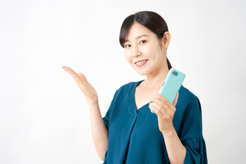 スマートフォンを持って左側を手のひらで指す女性　白背景