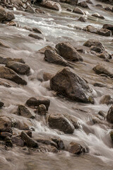 Water running in a river with moving water and rocks.