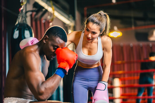 Young muscular african american male boxer looking at camera, wearing boxing gloves, standing isolated over grey background. Sports, workout and bodybuilding concept, confident african american boxer