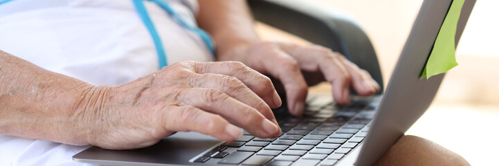 Closeup of aged business woman using computer.